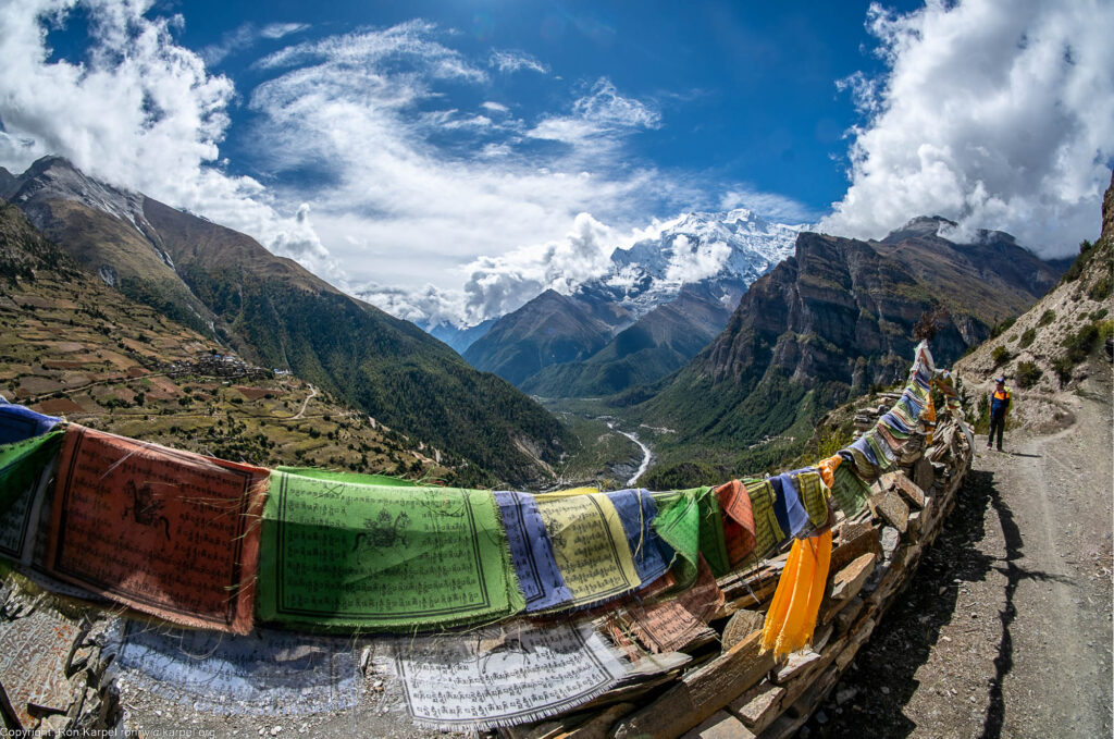 A line of prayer flags and a big snow capped mountain