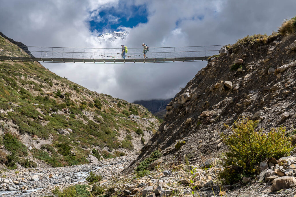 Hikers high on a suspension bridge