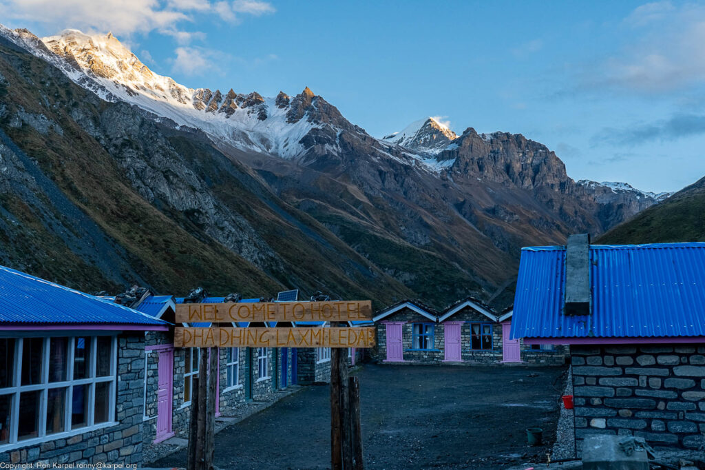 Cabins around a courtyard and a big snow capped mountain in the background